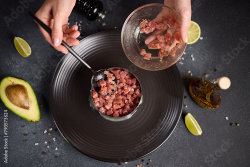 Tuna and avocado tartare recipe - woman fills cooking form with sliced chopped tuna fillet