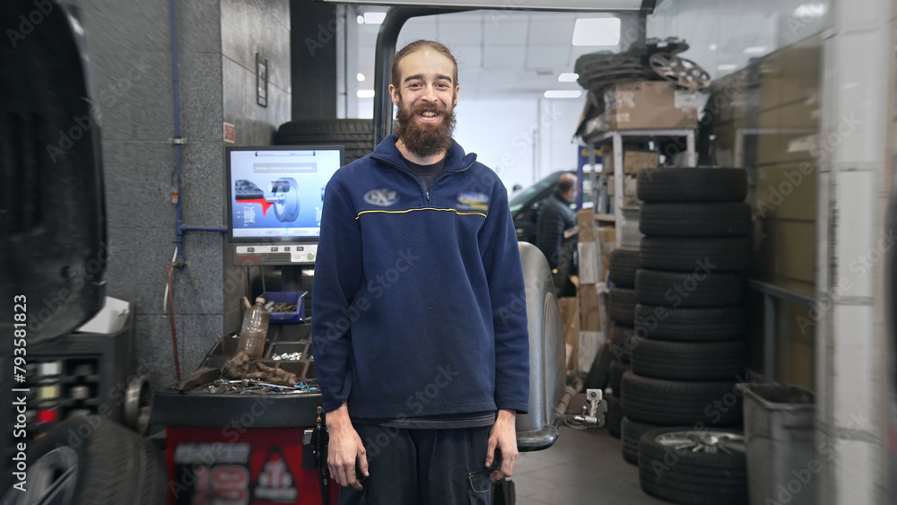 Technician work car service. Auto mechanic portrait. Cute smile engineer look at camera closeup. Man change tyre cover. Guy fix wheel at tire workshop. Happy worker repair. Repairman face close up.