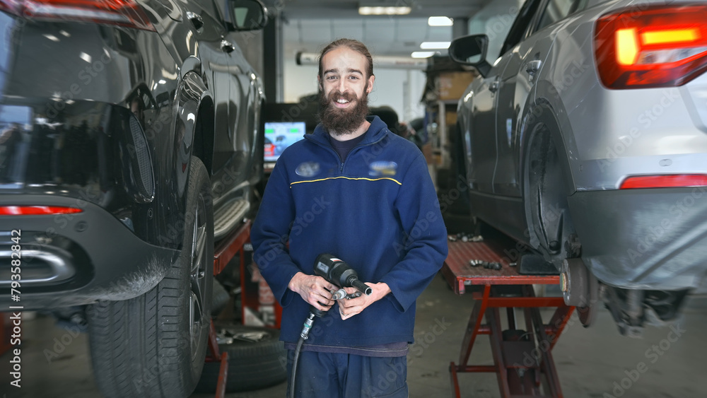 Technician work car service. Auto mechanic portrait. Cute smile engineer look camera. 30s man change tyre cover. Guy fix big wheel tire workshop. Happy worker repair cast disk. Repairman hold pistol. Technician work car service. Auto mechanic portrait. Cute smile engineer look camera. 30s man change tyre cover. Guy fix big wheel tire workshop. Happy worker repair cast disk. Repairman hold pistol.