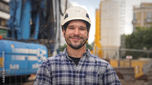 Confident construction site worker portrait. Smile constructor man look at camera. Builder engineer wear white helmet. Real estate agent plaid shirt. Guy build new house city street Erector person job photo