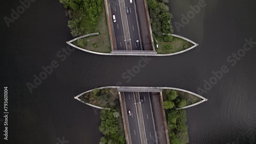 Steady top down aerial showing highway with traffic passing underneath Veluwemeer aquaduct seen from above. Dutch waterway infrastructure for boats to pass over  freeway. photo