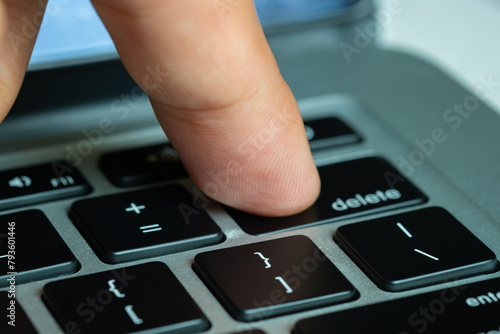 Fotografi Finger of the computer user, he presses the delete button on the computer keyboard