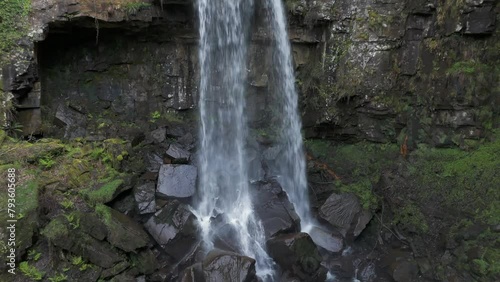 An aerial view of Melinclourt Waterfall on an overcast day, Neath Port Talbot, South Wales. Flying away from the fall while rising and tilting upwards photo