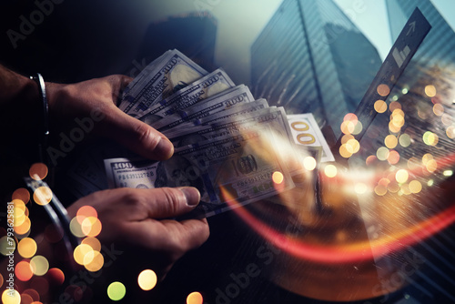  Double exposure city and hands of a man with handcuffs on a background of us dollars. Fraud, cyber crime concept. Arrest of an entrepreneur in the workplace. photo