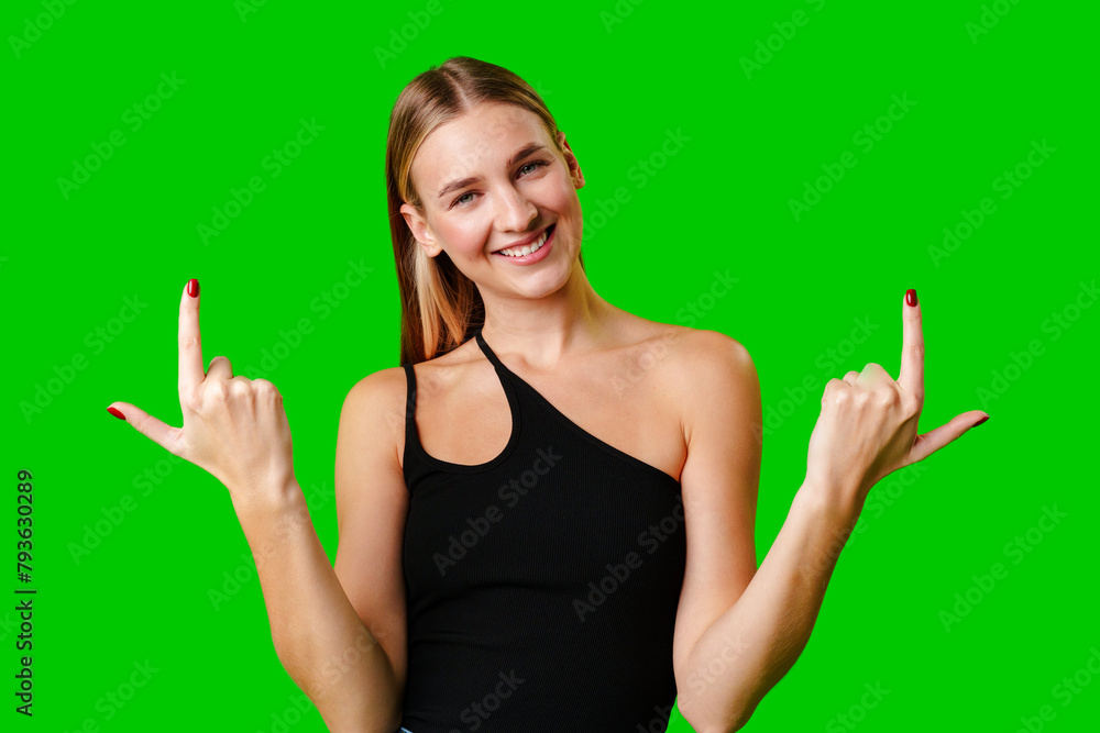 Young Woman Pointing Up Against Green Background Young Woman Pointing Up Against Green Background