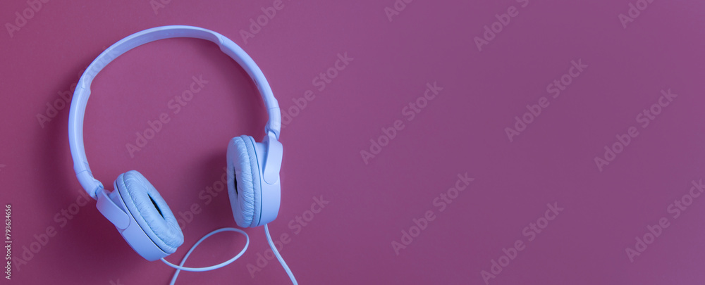 White headphones on a cherry background. copy space banner White headphones on a cherry background. copy space banner