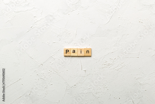 PAIN word written on wood block. PAIN text on cement table for your desing, concept