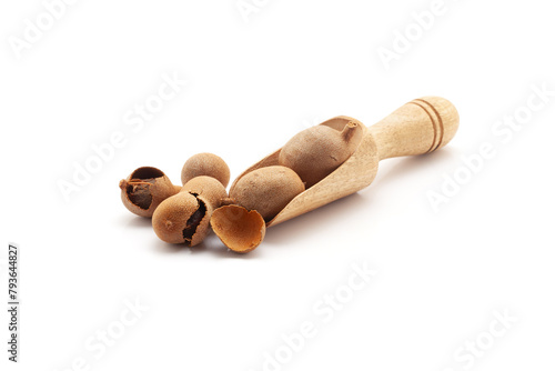 Front view of a wooden scoop filled with Fresh Organic Sweet Tamarind (Tamarindus indica) Frruit. Isolated on a white background. photo