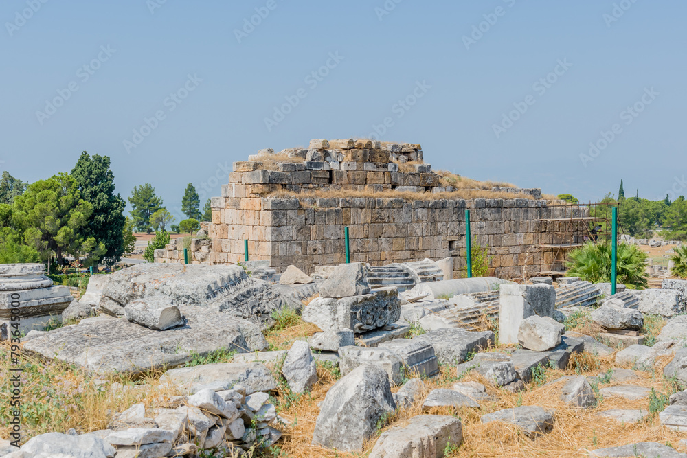 Stone blocks of an ancient ruins standing as a historic landmark against a clear blue sky at ancient site of Hierapolis in Pamukkale, Turkiye