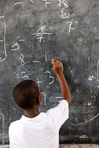 African school. Young boy learning mathematics.