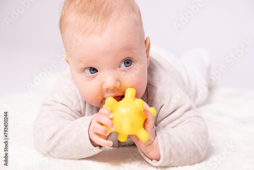 Pretty baby plays on the floor with a toy