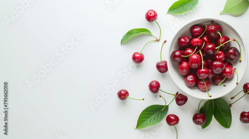 Red cherries in a bowl on a white table aerial view space on the left