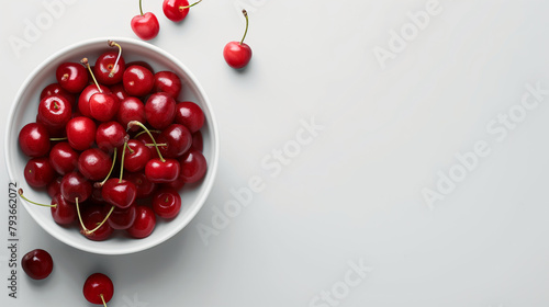 Red cherries in a bowl on a white table top view space on the right