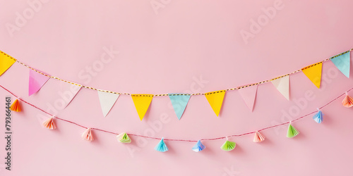 Festive banner with colorful paper garlands on a pink background. photo