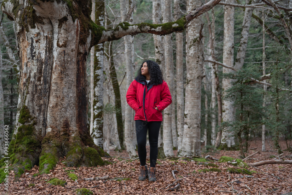 Hispanic woman walking through the forest in autumn Hispanic woman walking through the forest in autumn