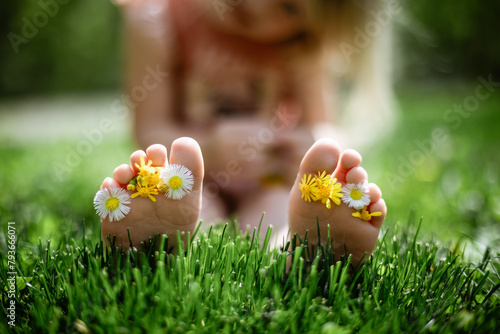 Wildflowers between little toes of child in grass photo