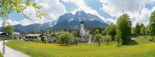 Landscape panorama of village church and cemetery Obergrainau, Wetterstein Mountains in spring photo
