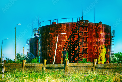 Old rusty oil tanks (fuel reservoir, oil barrel). Evidence of economic stagnation and environmental pollution