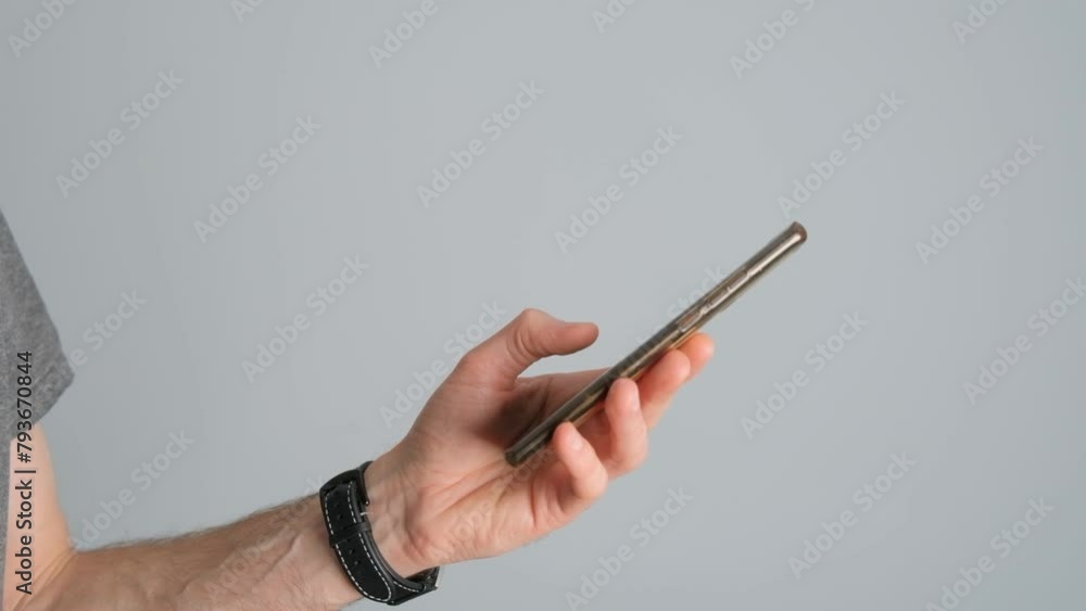 Close-up of a man holding a smartphone in his hand on a black background. Close-up of a man holding a smartphone in his hand on a black background.
