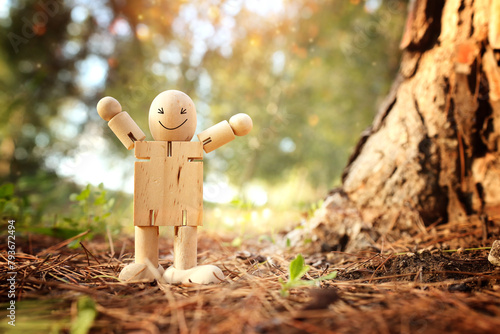 Wooden figure in nature with smiling face. Concept of joy happiness and wellness