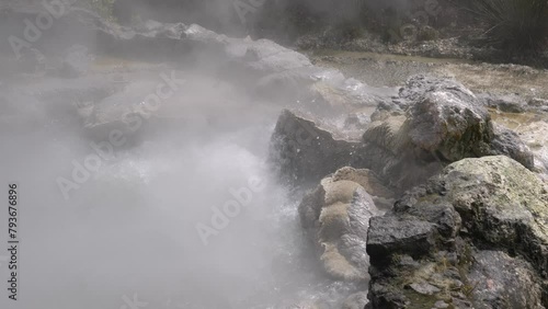 Slow motion closeup of a volcanic spring spilling out hot water photo