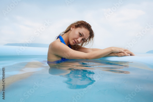a girl in a swimsuit swims in the pool in a hot summer  the concept of a hot summer