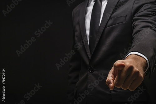  a businessman in a suit pointing with his finger on a black background
