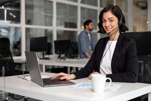 Happy smiling female customer support phone operator at workplace