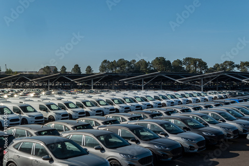 Centro de distribuição de carros novos em estacionamento. Muitos veículos aguardando venda ou distribuição para o cliente final. Indústria automobilística