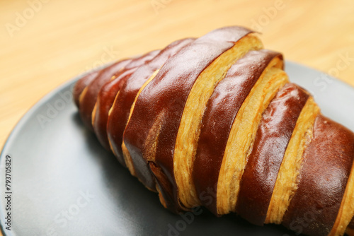 Closeup of a Bicolored Chocolate Croissant Served on Black Plate