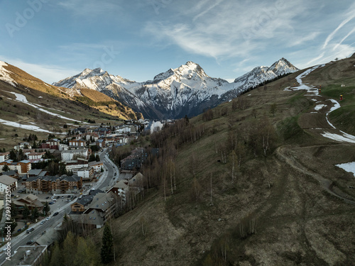 Town in the alps mountains during sunset. Aerial drone photo. French alps in winter, Rhone Alpes in France Europe . Les deux alpes village in spring time. Winter French Alpes town from drone.