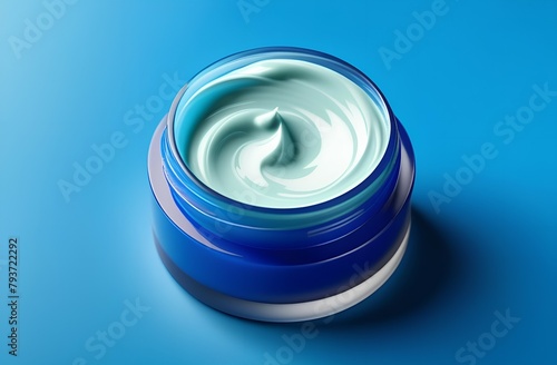 Face cream moisturiser in a container on blue background, body care and skincare cosmetic product.