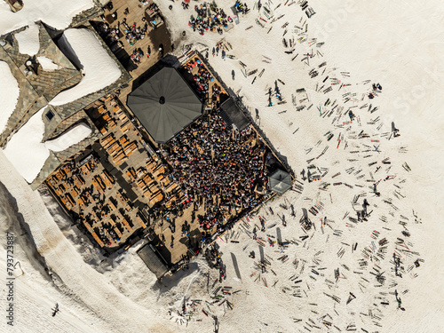 People dancing in a mountain bar in the ski resort of Les 2 Alpes, France. Aerial drone view of people enjoying apres-ski. Apres ski in a mountain chalet bar. les deux alpes. Apres ski in alps.