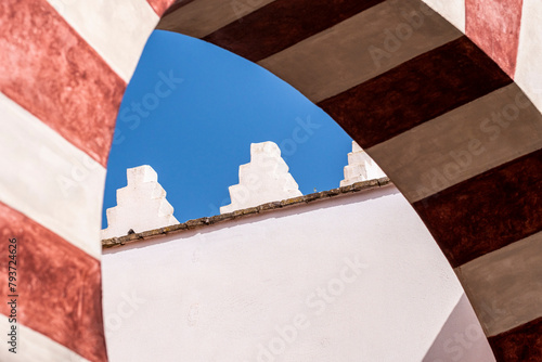 A close-up view of a structure in Cordoba, Andalusia, Spain captures the geometric shapes and contrasts between the red-striped arch and the sky, showcasing Europe's travel wonders photo
