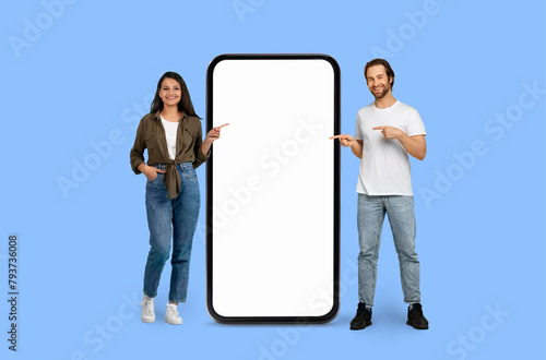 Two Multiracial people gesturing towards a large phone screen
