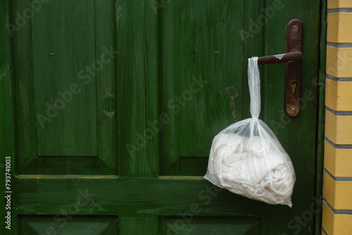 jumper in a bag on a door handle © fafikowiec