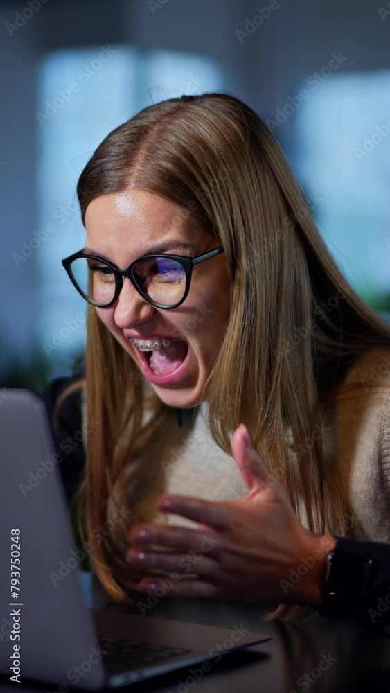 Woman sitting at computer, working on it and gets angry about something. Office employee screaming and waving hands in front of laptop. Vertical video Woman sitting at computer, working on it and gets angry about something. Office employee screaming and waving hands in front of laptop. Vertical video