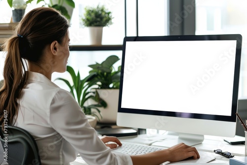 Digital mockup caucasian woman in her 40s in front of a computer with a completely white screen