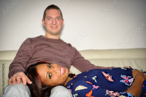 Multiracial couple with her, in the foreground, with her head on his lap, blurred in the background
