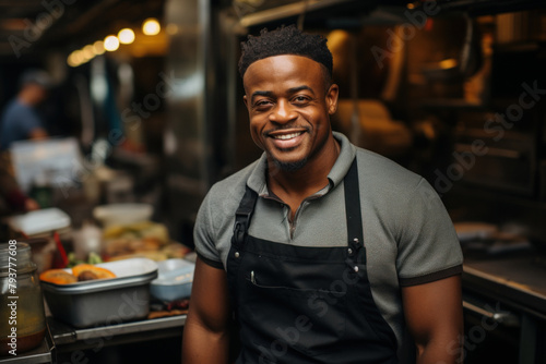 A friendly male employee in an apron in a street restaurant.