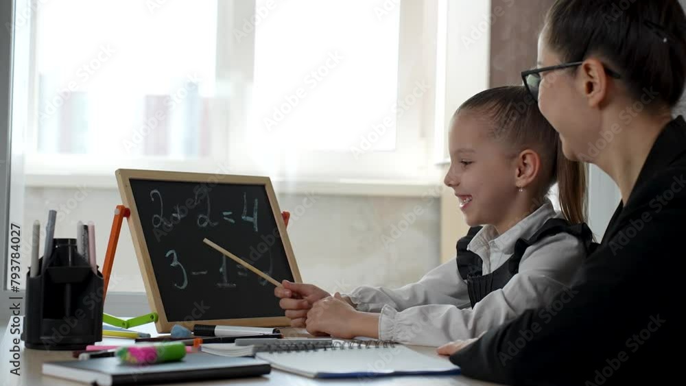 Female teacher teaching kid math using chalkboard Female teacher teaching kid math using chalkboard