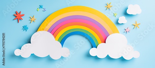 A rainbow paper cut with clouds on blue backdrop