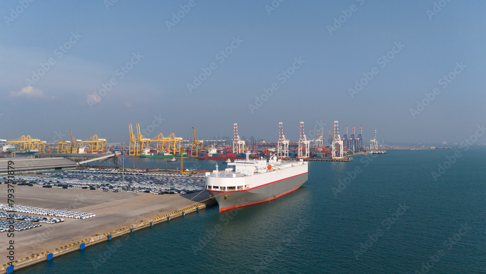 Aerial drone photo of large car carrier ro ro vessel guided by tug boats to dock to Mediterranean port.