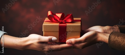 Person offers gift red bow photo