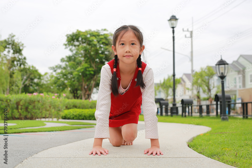 Portrait of Asian girl kid prepare for start to run in the garden.