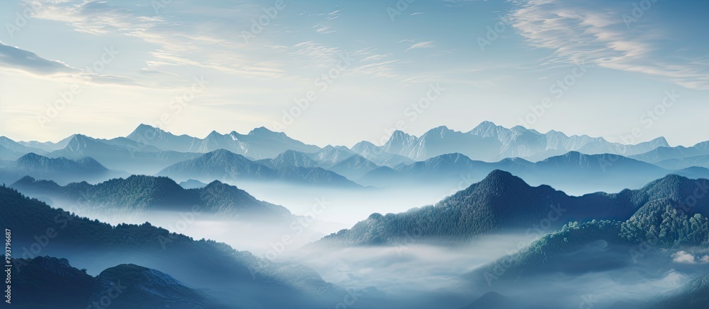 Mountains wrapped in mist under a blue sky Mountains wrapped in mist under a blue sky