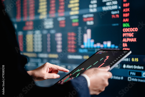 Investors analyze the data stock market index via digital tablet screen to trade the stock chart for planning investments take profit, trade stock exchange market and cryptocurrency data, financial.