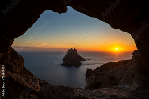 Es Vedra islet view through the rock hole of a cave at sunset, Sant Josep de Sa Talaia, Ibiza, Balearic Islands, Spain
 photo