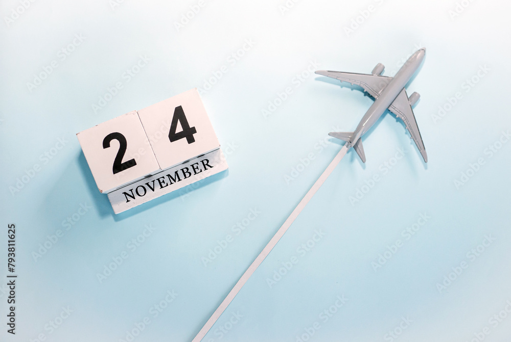 November calendar with number  24. Top view of a calendar with a flying passenger plane. Scheduler. Travel concept. Copy space.