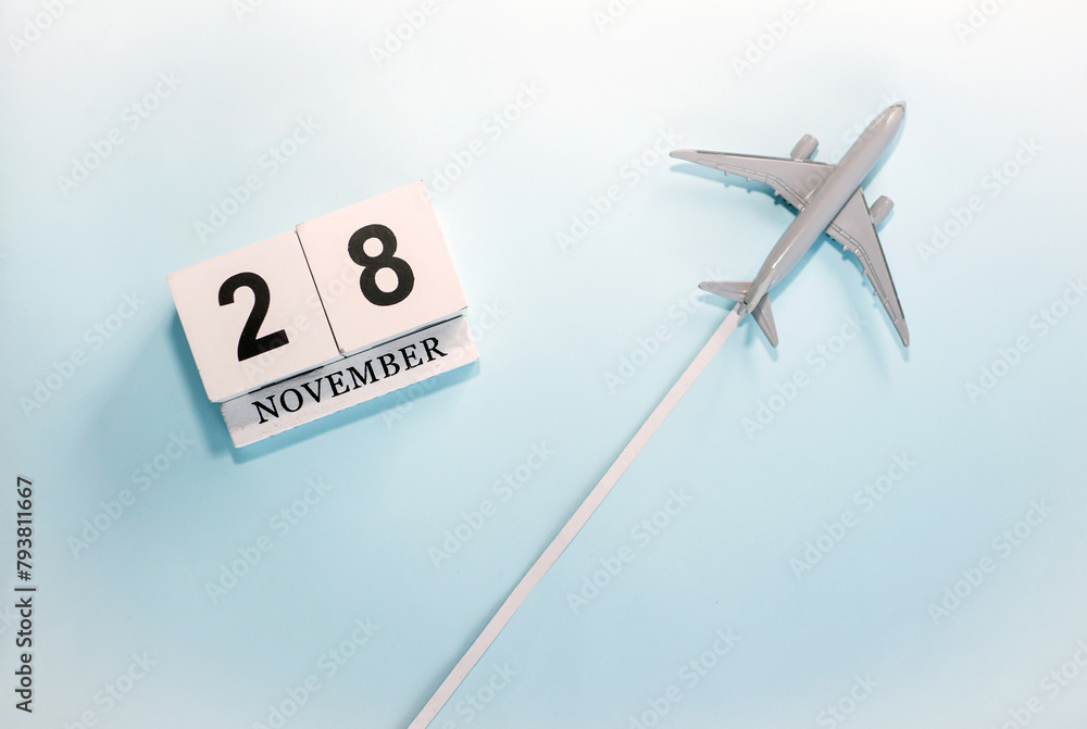 November calendar with number 28. Top view of a calendar with a flying passenger plane. Scheduler. Travel concept. Copy space. November calendar with number 28. Top view of a calendar with a flying passenger plane. Scheduler. Travel concept. Copy space.